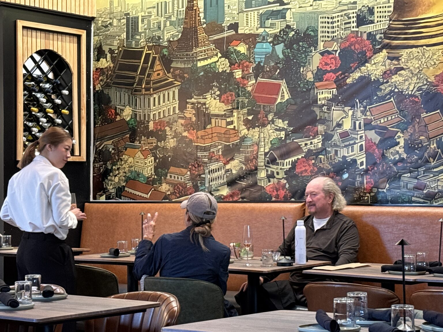 The interior at Charoen Krung by Sathorn with a large Thai mural.