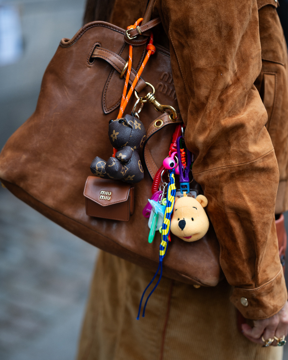 A brown suede Miu Miu bag with an array of colorful vintage charms.