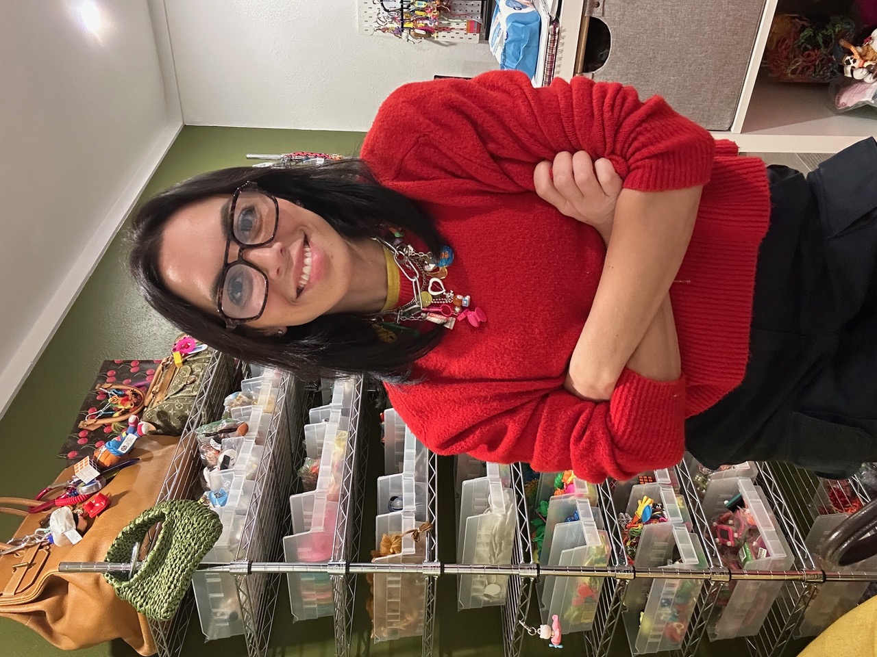 Amanda Marcuson in her studio surrounded by shelves of vintage charms and merchandise.