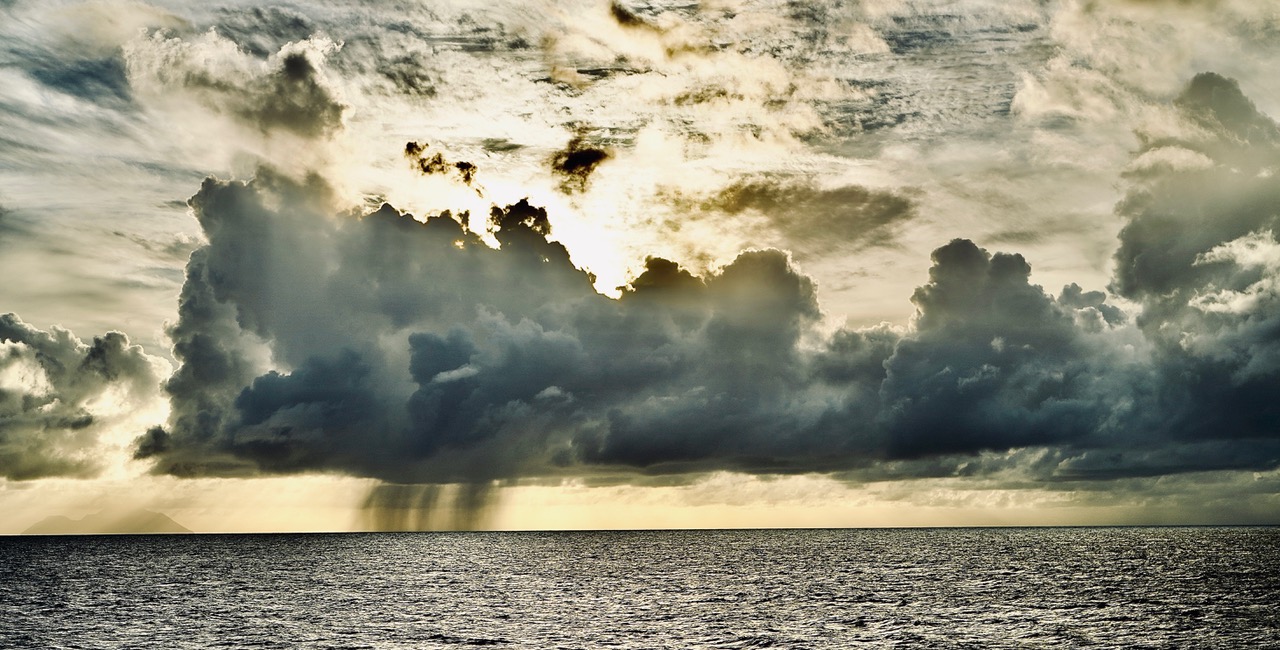 Dramatic storm clouds and sunbeams over the Caribbean sea.