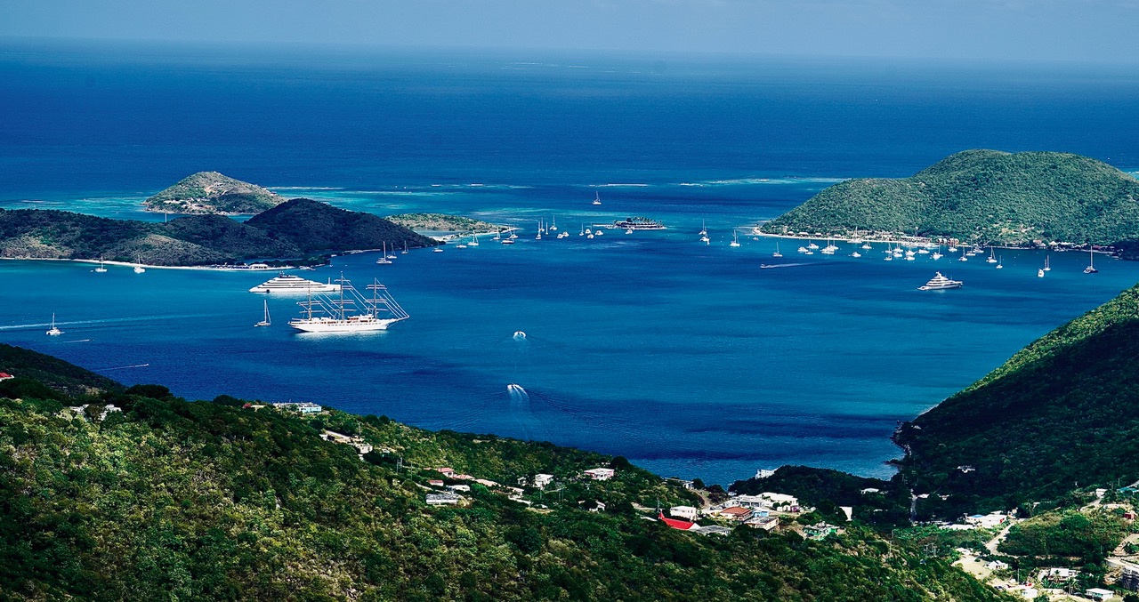 Aerial view of a Caribbean harbor with the Sea Cloud Spirit anchored among yachts and sailboats.