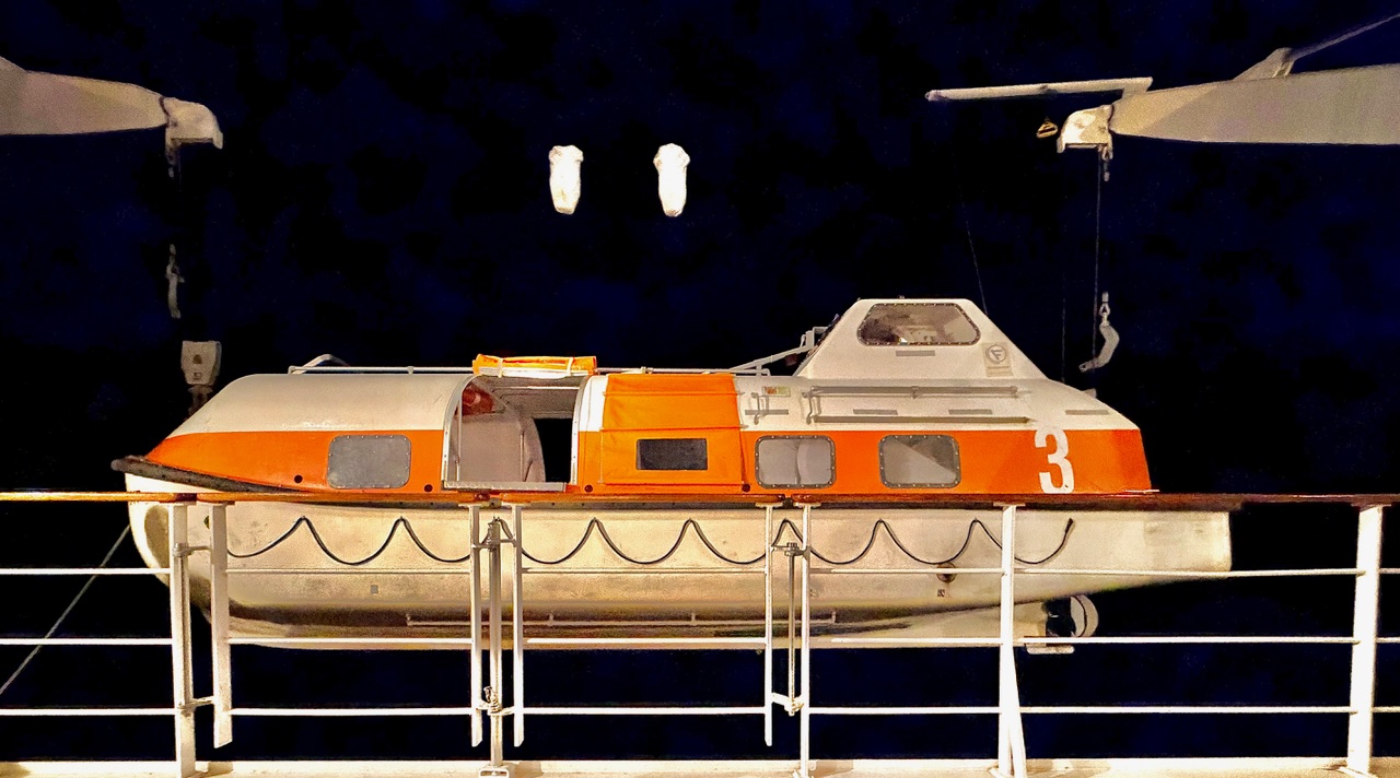 The ship's tender illuminated at night, ready for launch.