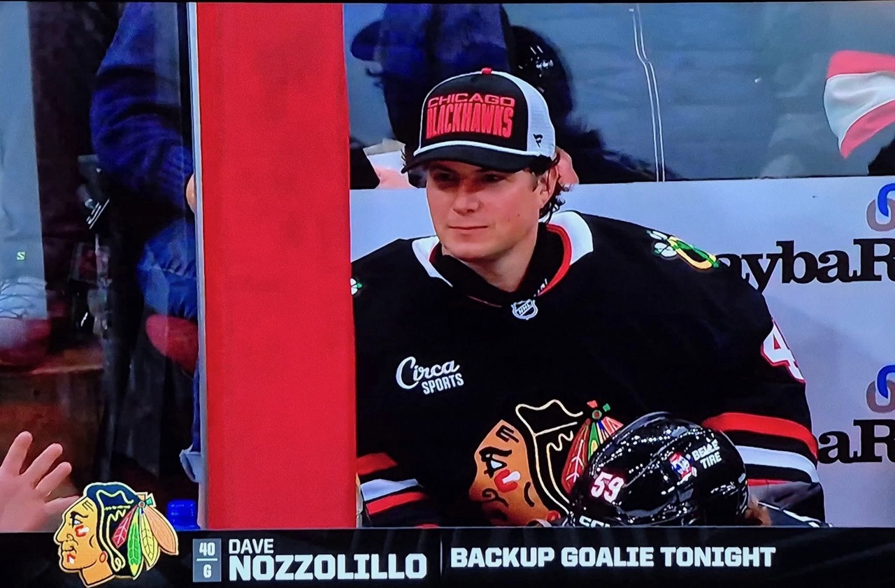Dave Nozzolillo on the bench at the United Center, identified on the TV broadcast as 'Backup Goalie Tonight.'