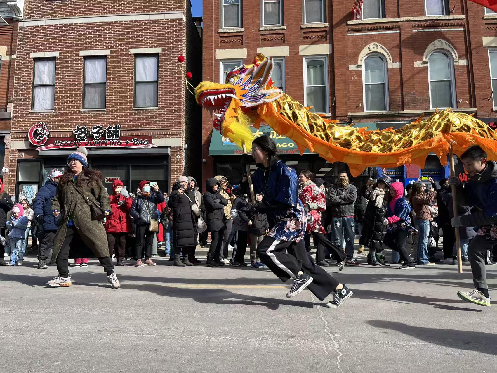 Dragon dancer carrying a golden dragon through the crowd at the Chinatown Lunar New Year Parade