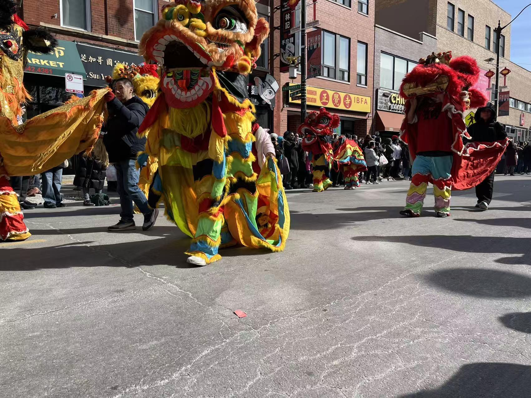 Colorful lion dancers performing low to the ground in the Lunar New Year Parade