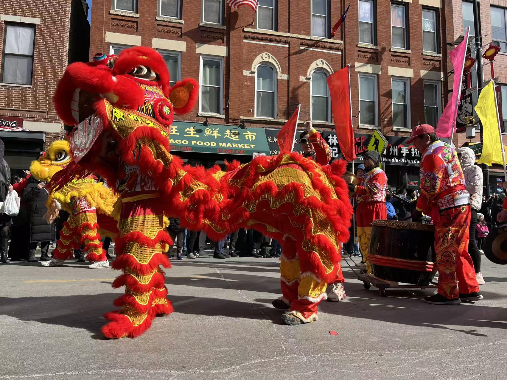 Red and gold lion dancers performing in the 2026 Chinatown Lunar New Year Parade