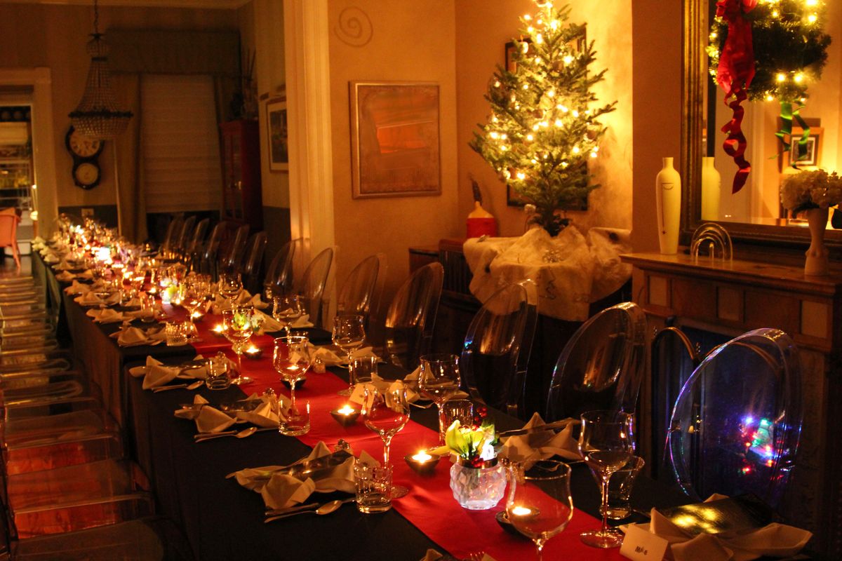 Formal dinner table with red tablecloth, tall candles, crystal glassware, and candelabras