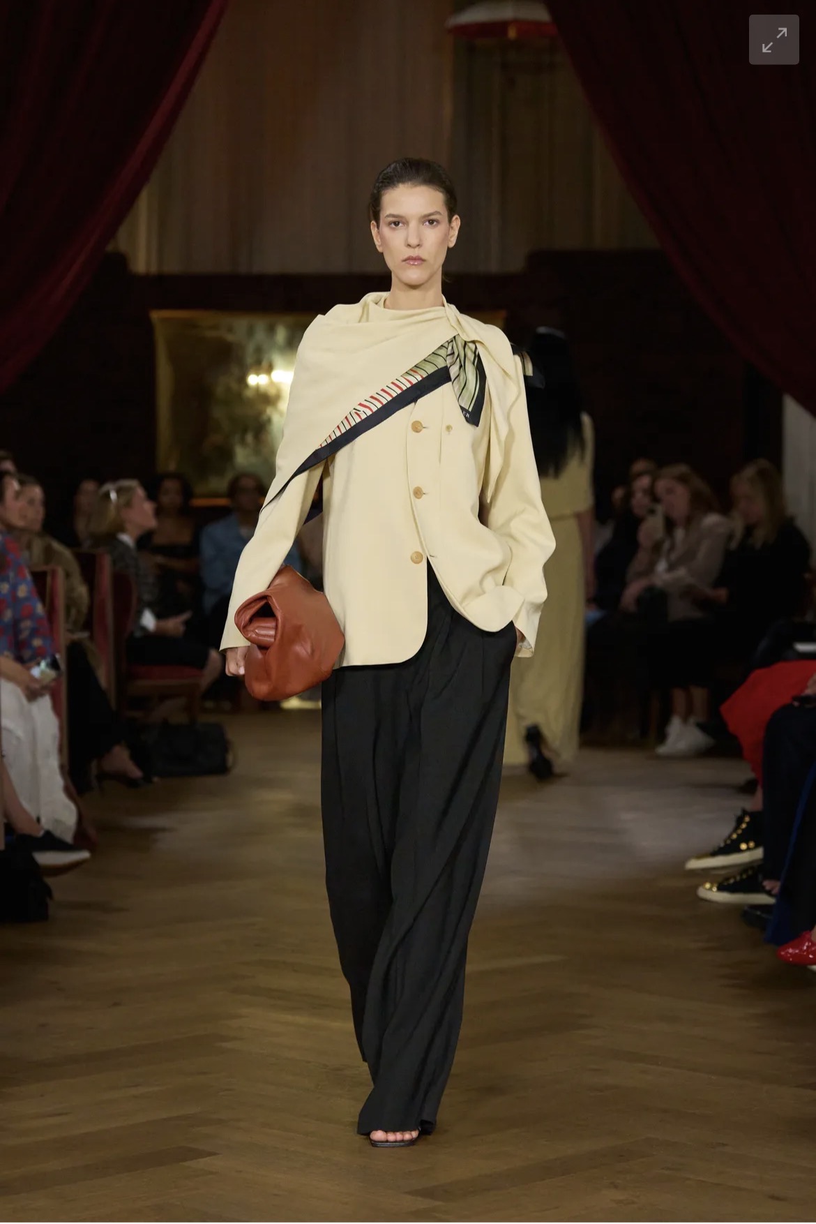 Layered runway look with scarf tied at shoulder