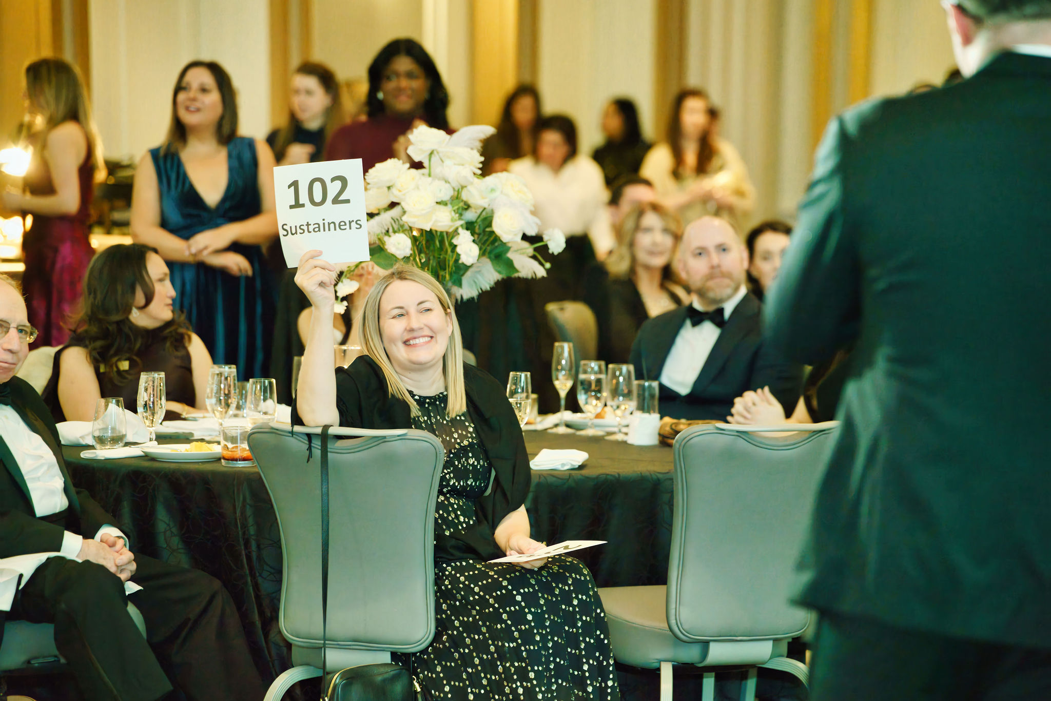 JLC Board Member at Large Danielle LaChance raises paddle on behalf of JLC Sustaining Members