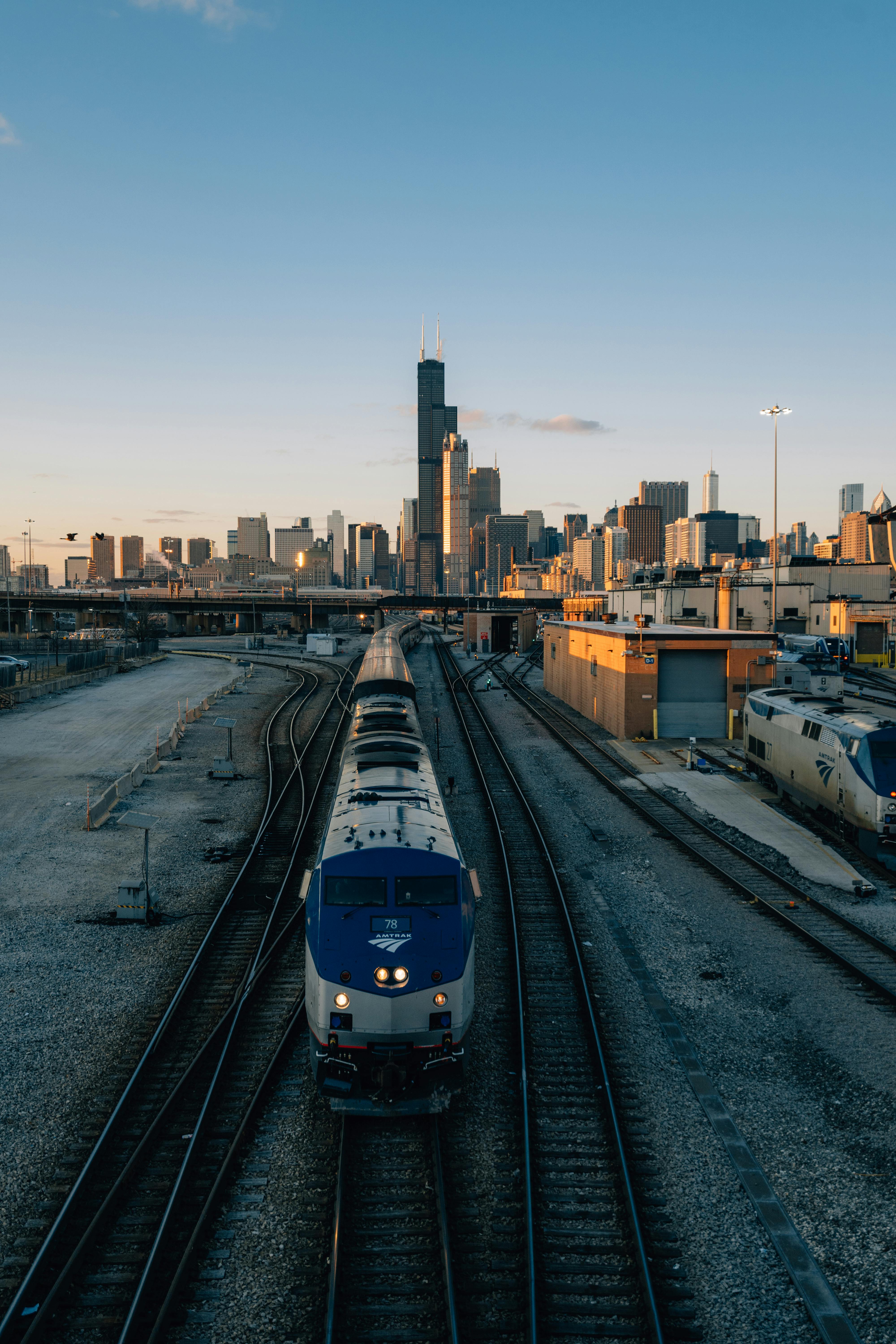 An Amtrak train winds its way east out of the city at sunset
