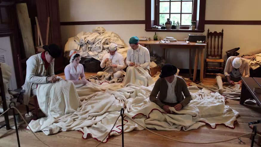Volunteers in Revolutionary-era costume sewing the tent replica