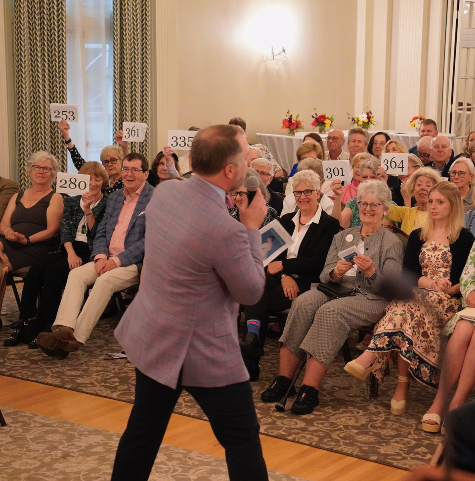 John Walcher of Toomey & Co. Auctioneers leads the paddle raise