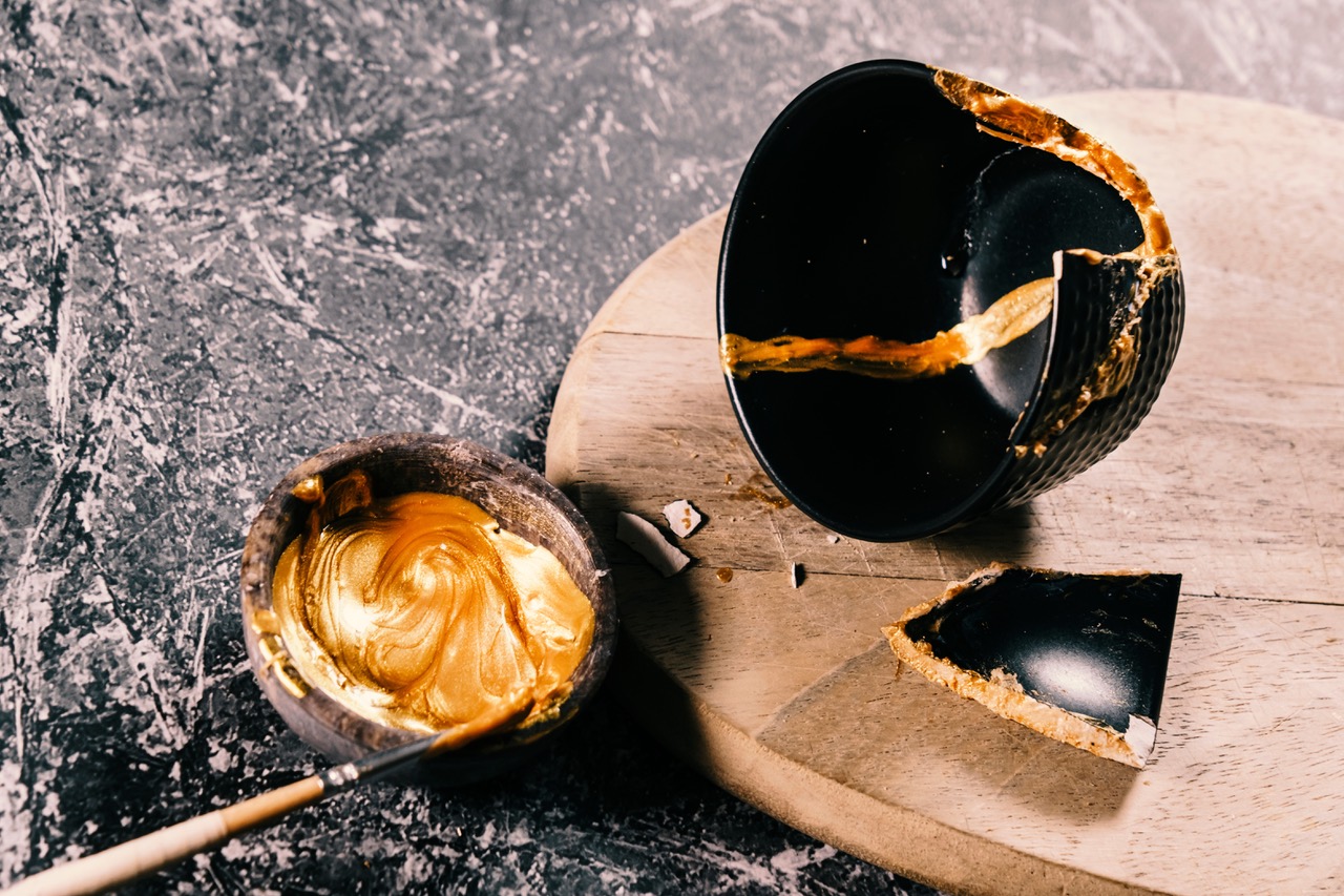 Black bowl being repaired with gold lacquer