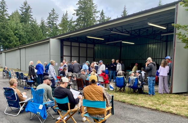 Island lot owners assemble at an airplane hangar for the annual meeting