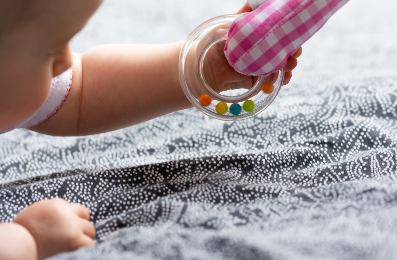 A baby holding a rattle