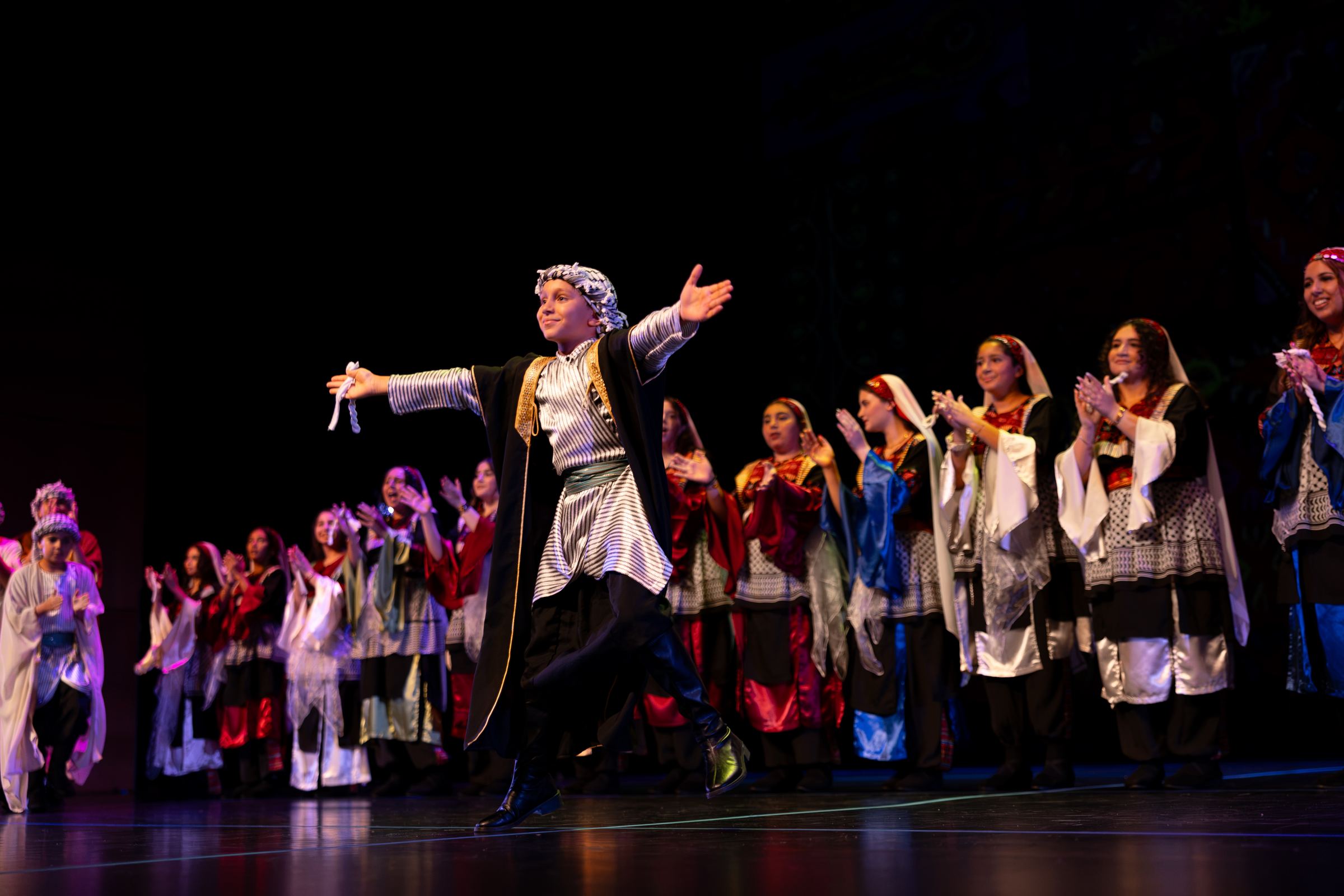 A Canaan Wellspring dancer performing dabke on stage