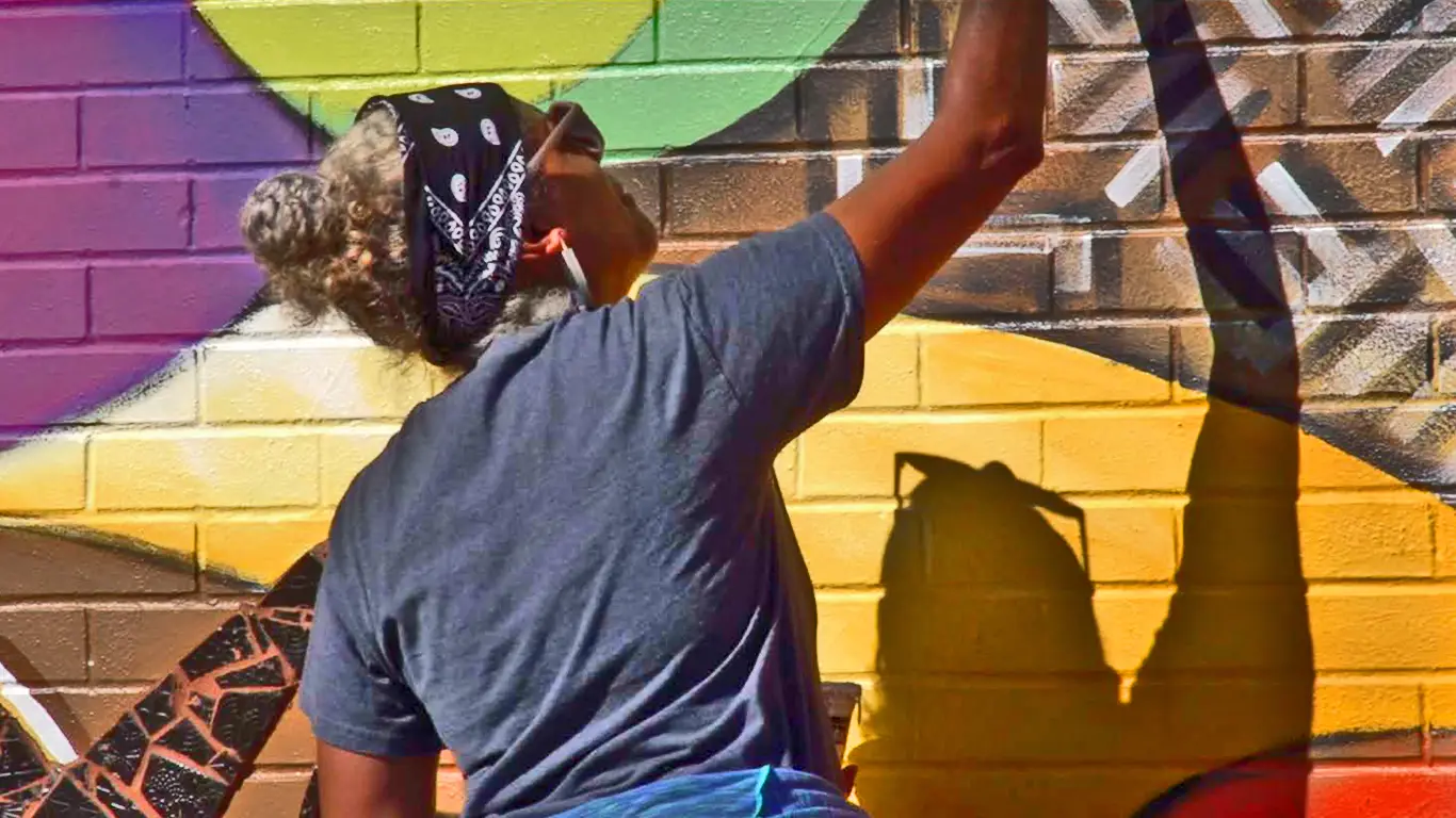 A view of artist Dorian Sylvain creating a mural. Courtesy of doriansylvain.com